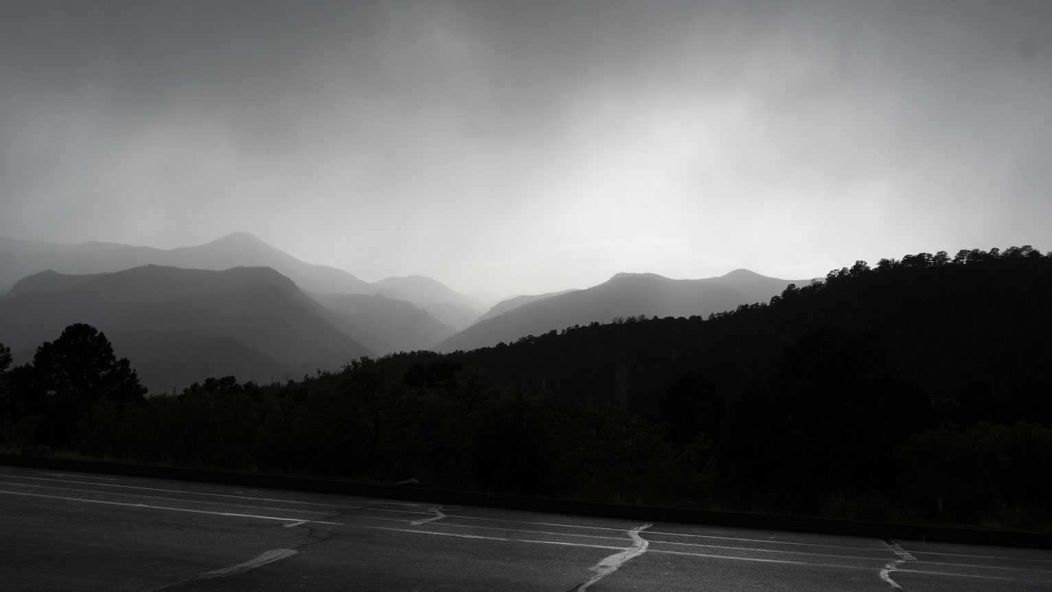 Monochrome slopes of mountains in a haze of rain